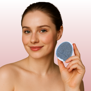 Hand holding Bubblux Facial Vibrating Cleanser for deep pore cleansing and gentle facial exfoliation, shown against a soft pink background.